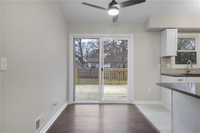 unfurnished dining area featuring ceiling fan, sink, and hardwood / wood-style flooring