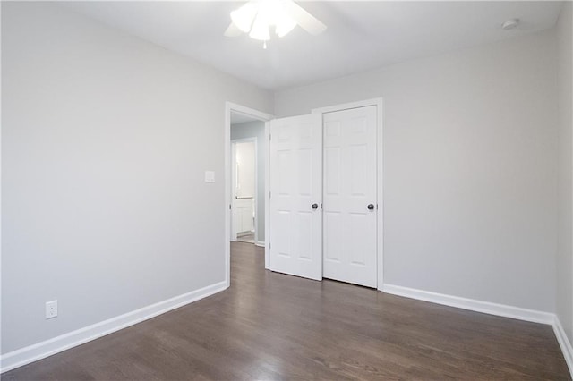 unfurnished bedroom featuring ceiling fan, a closet, and dark wood-type flooring