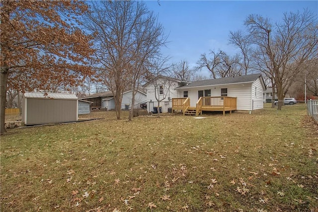 rear view of property featuring a lawn, a storage unit, and a deck