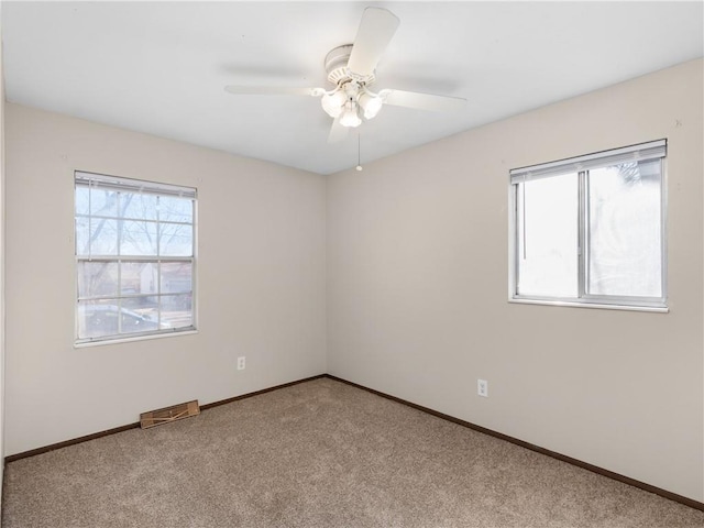 empty room with light colored carpet, plenty of natural light, and ceiling fan