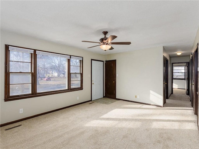 carpeted spare room featuring ceiling fan