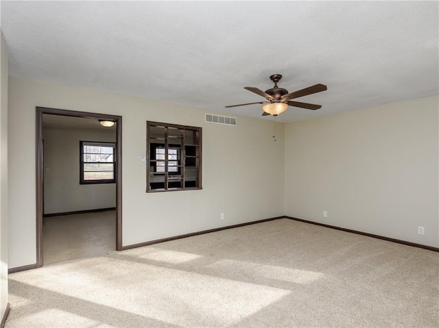 spare room with ceiling fan and light colored carpet