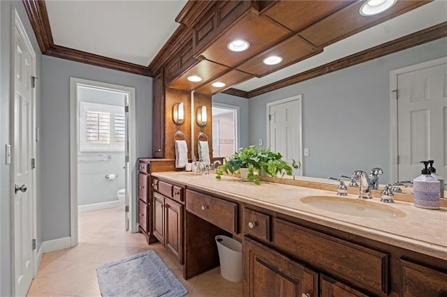 bathroom with toilet, vanity, tile patterned floors, and ornamental molding