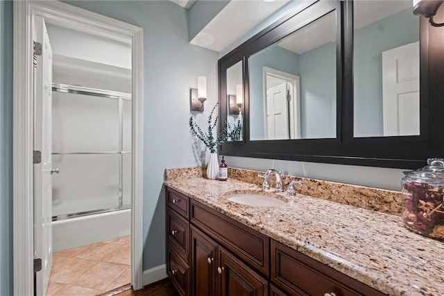 bathroom with tile patterned floors, enclosed tub / shower combo, and vanity