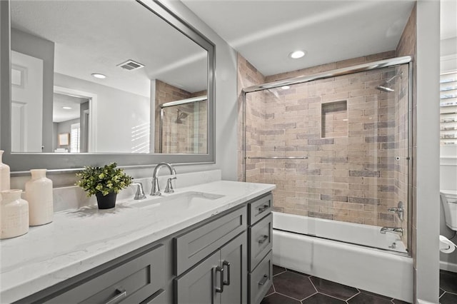 full bathroom featuring tile patterned floors, toilet, vanity, and shower / bath combination with glass door