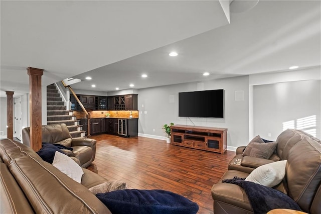 living room with dark wood-type flooring and ornate columns