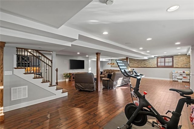 workout area with dark hardwood / wood-style flooring and decorative columns