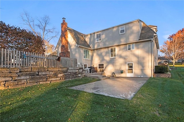 rear view of house with a lawn and a patio