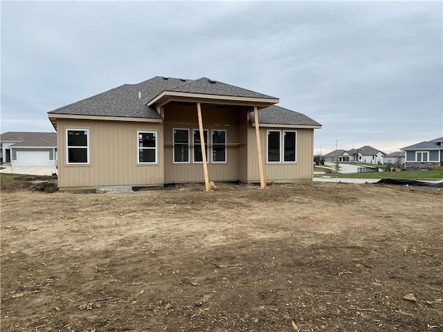 back of property with roof with shingles