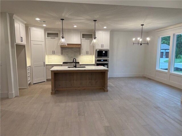 9301 SW Leviathan Ct, Lees Summit, MO 64064 - kitchen with stainless steel appliances, a sink, a chandelier, backsplash, and light countertops