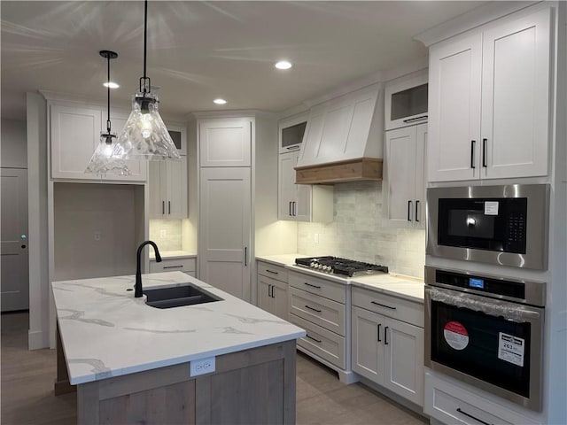 9301 SW Leviathan Ct, Lees Summit, MO 64064 - kitchen featuring stainless steel appliances, a sink, light stone counters, glass insert cabinets, and recessed lighting