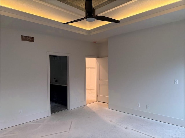 9301 SW Leviathan Ct, Lees Summit, MO 64064 - unfurnished bedroom featuring a raised ceiling, ensuite bath, baseboards, and a ceiling fan
