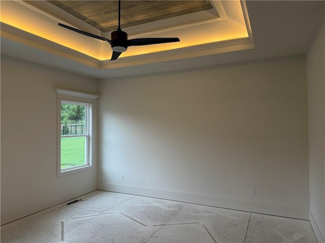 9301 SW Leviathan Ct, Lees Summit, MO 64064 - spare room with a raised ceiling, baseboards, and a ceiling fan
