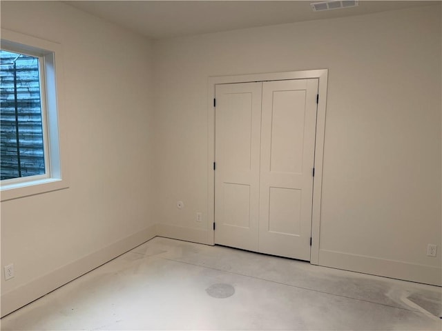 9301 SW Leviathan Ct, Lees Summit, MO 64064 - unfurnished bedroom with concrete floors, baseboards, and a closet