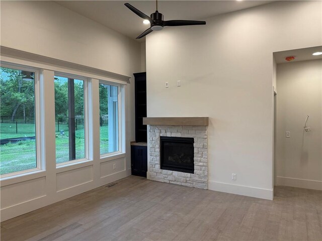9301 SW Leviathan Ct, Lees Summit, MO 64064 - unfurnished living room with a ceiling fan, wood finished floors, and a stone fireplace