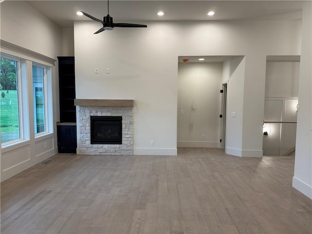 9301 SW Leviathan Ct, Lees Summit, MO 64064 - unfurnished living room featuring ceiling fan, plenty of natural light, wood finished floors, a fireplace, and recessed lighting