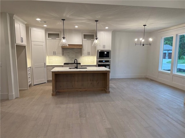 9301 SW Leviathan Ct, Lees Summit, MO 64064 - kitchen with stainless steel appliances, decorative backsplash, light countertops, a chandelier, and white cabinets