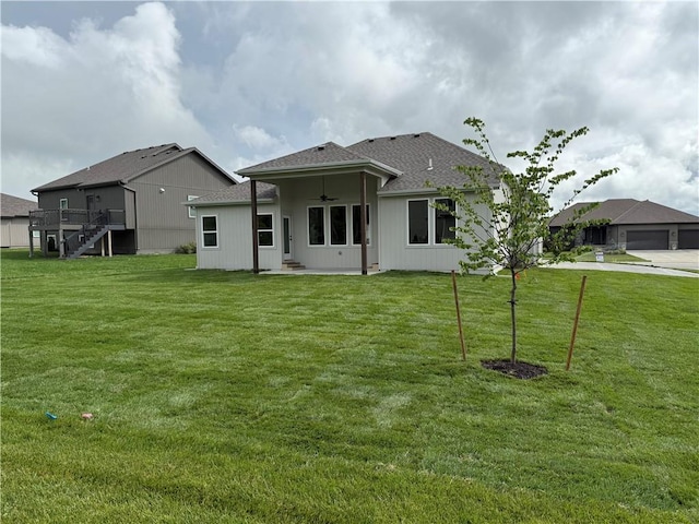 9301 SW Leviathan Ct, Lees Summit, MO 64064 - back of property with ceiling fan, a yard, roof with shingles, and stairs