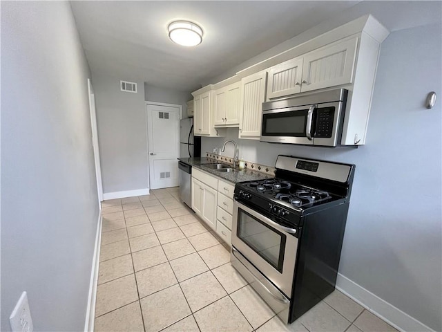 kitchen featuring light tile patterned flooring, white cabinetry, sink, and appliances with stainless steel finishes