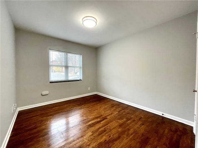 unfurnished room with dark hardwood / wood-style flooring