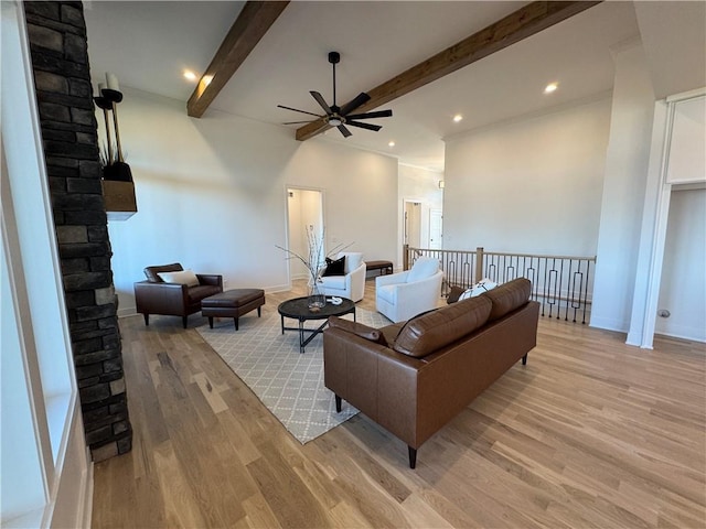 living room with beam ceiling, light wood-type flooring, and ceiling fan