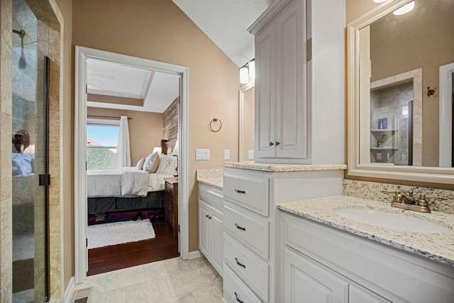 bathroom featuring a shower with door, vanity, and lofted ceiling