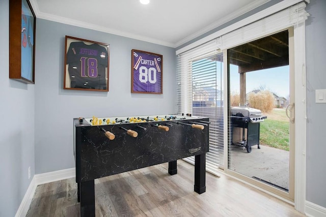 game room with hardwood / wood-style flooring and ornamental molding