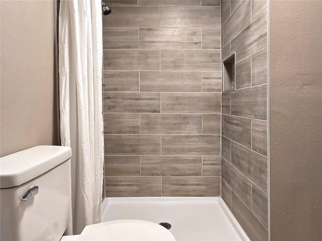 bathroom featuring a shower with curtain and toilet