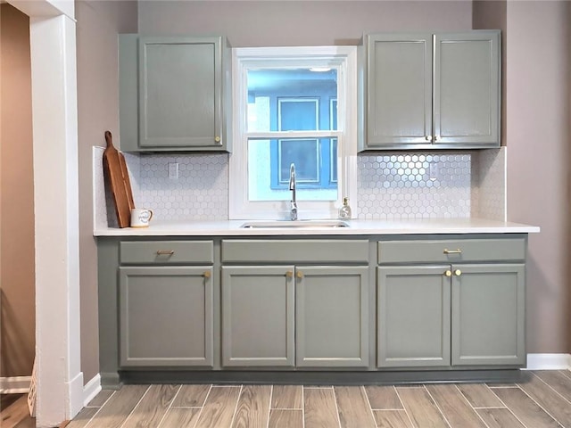 kitchen featuring tasteful backsplash, gray cabinets, and sink