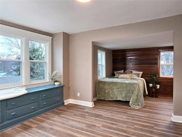 bedroom featuring wood-type flooring and wooden walls