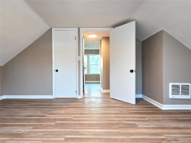 bonus room with light hardwood / wood-style flooring and vaulted ceiling