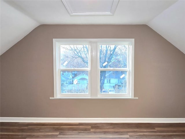 additional living space with hardwood / wood-style floors and vaulted ceiling