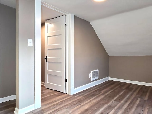 additional living space with dark hardwood / wood-style flooring and vaulted ceiling