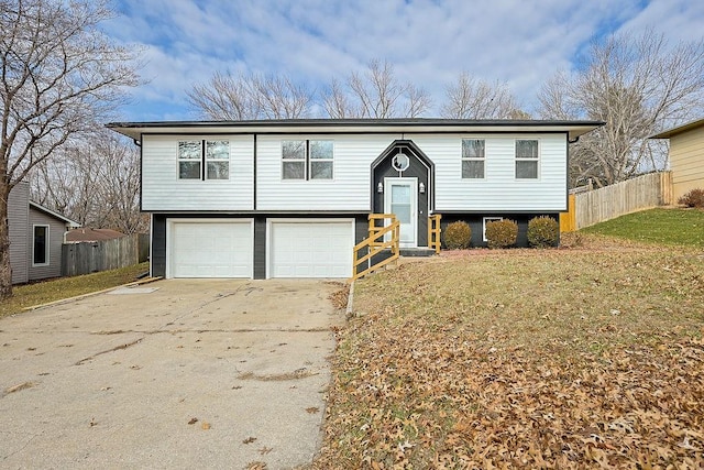 bi-level home with a garage and a front lawn