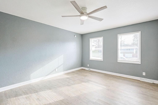 spare room with ceiling fan and light wood-type flooring