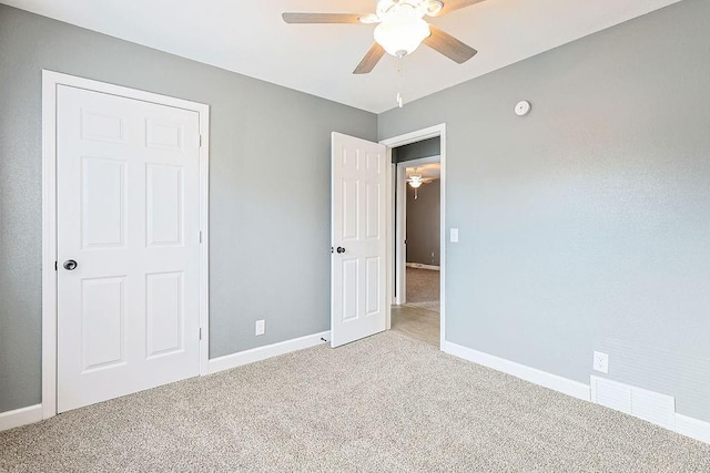 unfurnished bedroom featuring a closet, light colored carpet, and ceiling fan