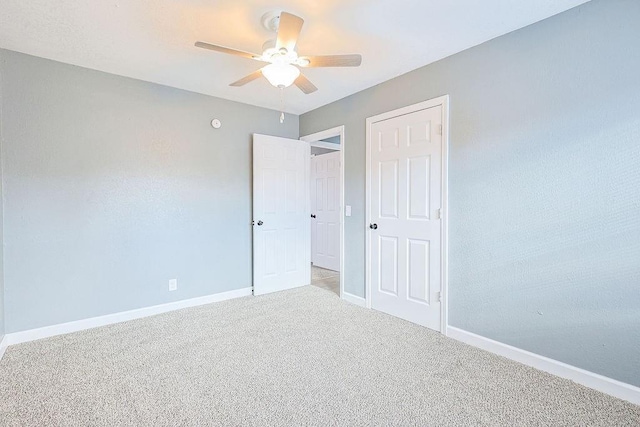 unfurnished bedroom featuring light colored carpet and ceiling fan