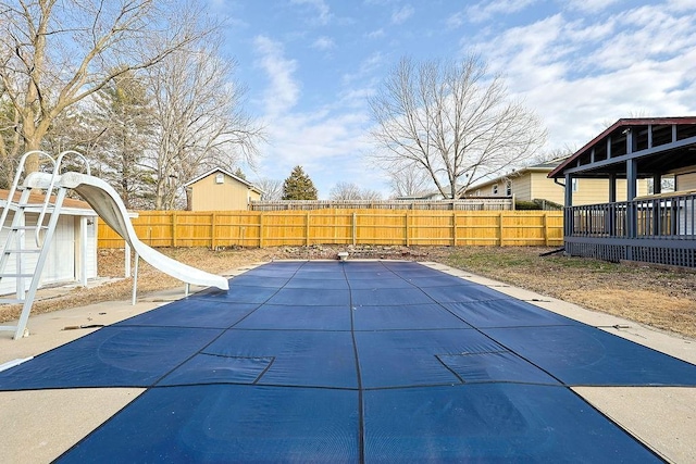 view of pool with a water slide and a patio