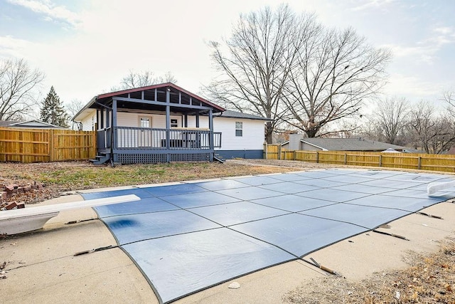 view of swimming pool featuring a diving board, a patio area, and a wooden deck