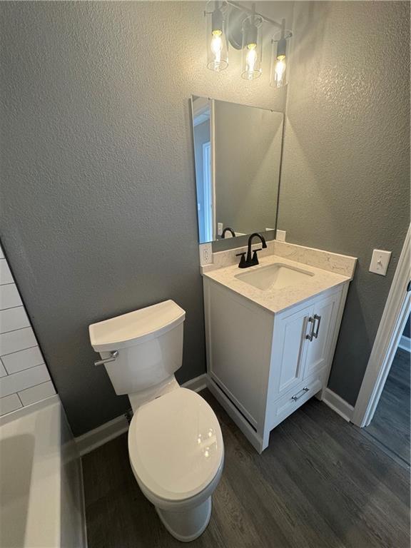 bathroom featuring wood-type flooring, vanity, and toilet