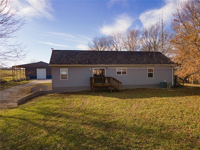 back of house featuring an outbuilding, a yard, a garage, and central air condition unit