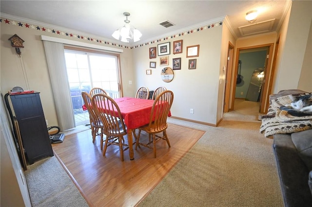 carpeted dining room with crown molding and a notable chandelier