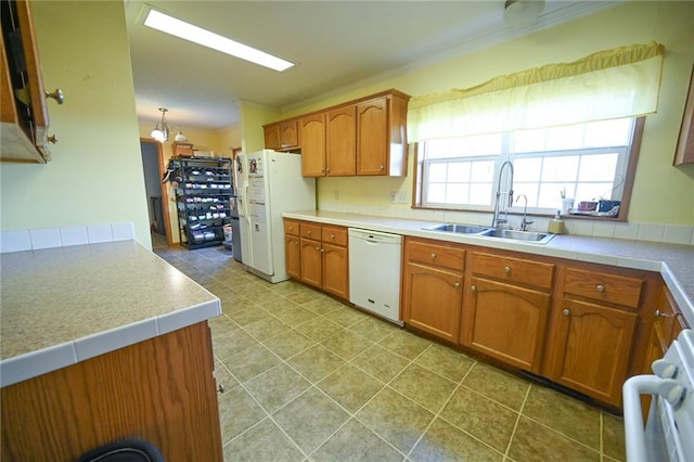 kitchen featuring white appliances, an inviting chandelier, crown molding, sink, and decorative light fixtures