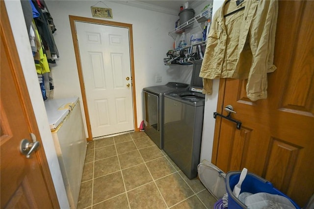 washroom with washer and clothes dryer, crown molding, and dark tile patterned flooring