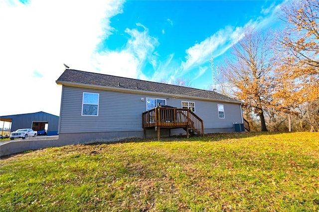 back of property with central air condition unit, a wooden deck, and a yard