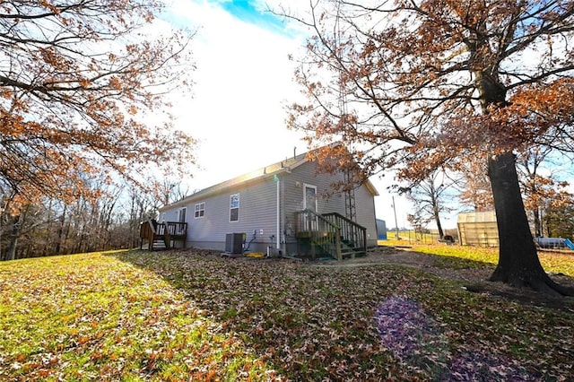 view of property exterior featuring a lawn and central AC