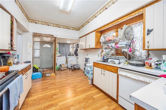 kitchen with white dishwasher, white cabinets, and sink