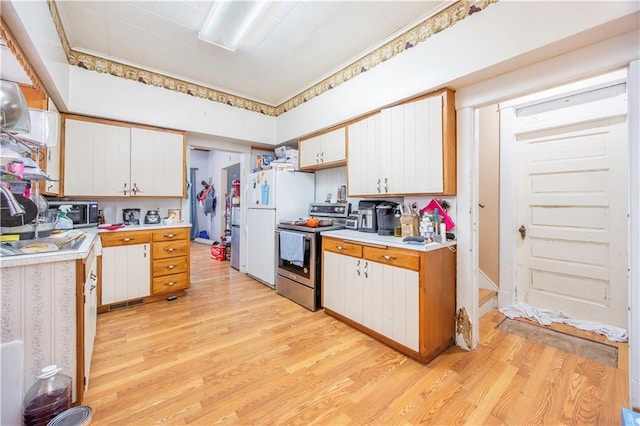 kitchen featuring appliances with stainless steel finishes, light wood-type flooring, and white cabinetry