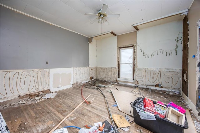 empty room with wood-type flooring, ceiling fan, and ornamental molding