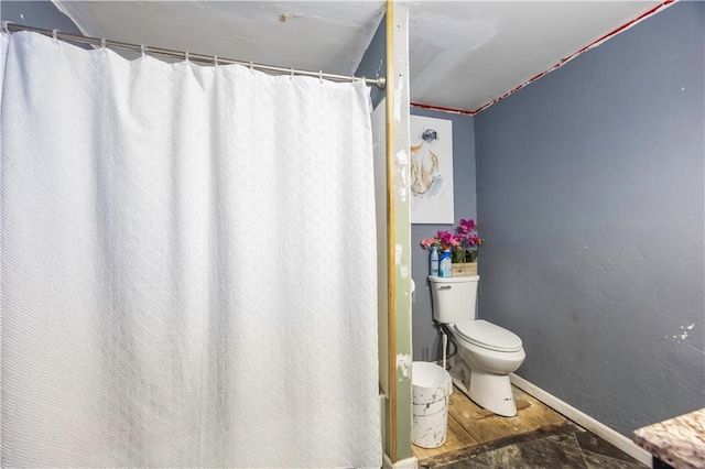 bathroom with a shower with shower curtain and toilet